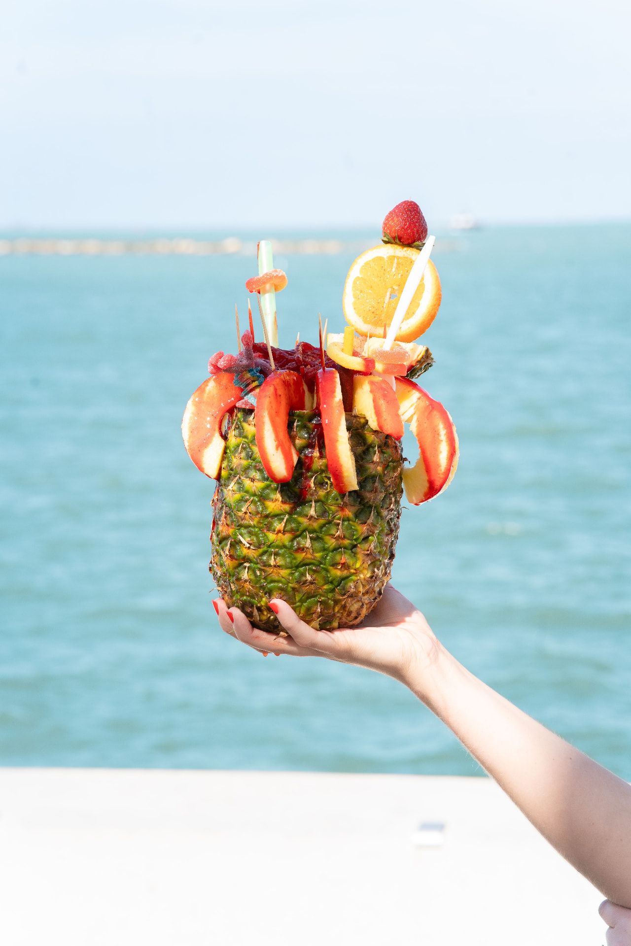Tropical cocktail served in a pineapple beside the sea