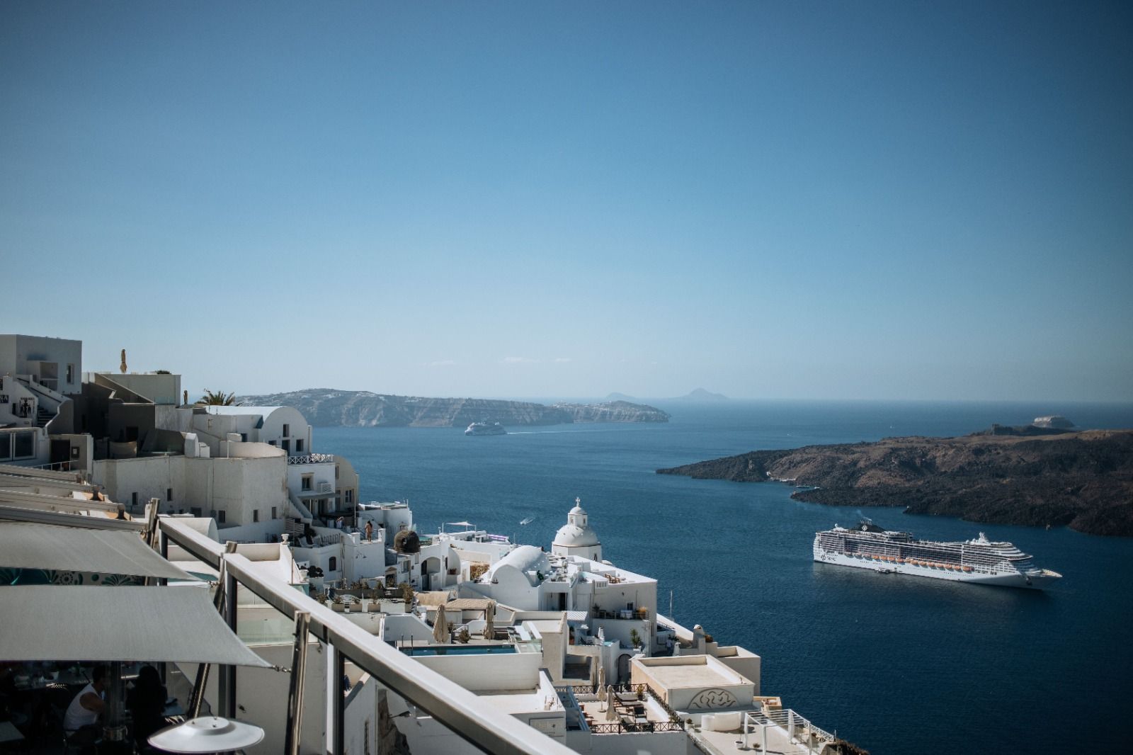 Santorini town, volcanic caldera and a cruise ship in the water