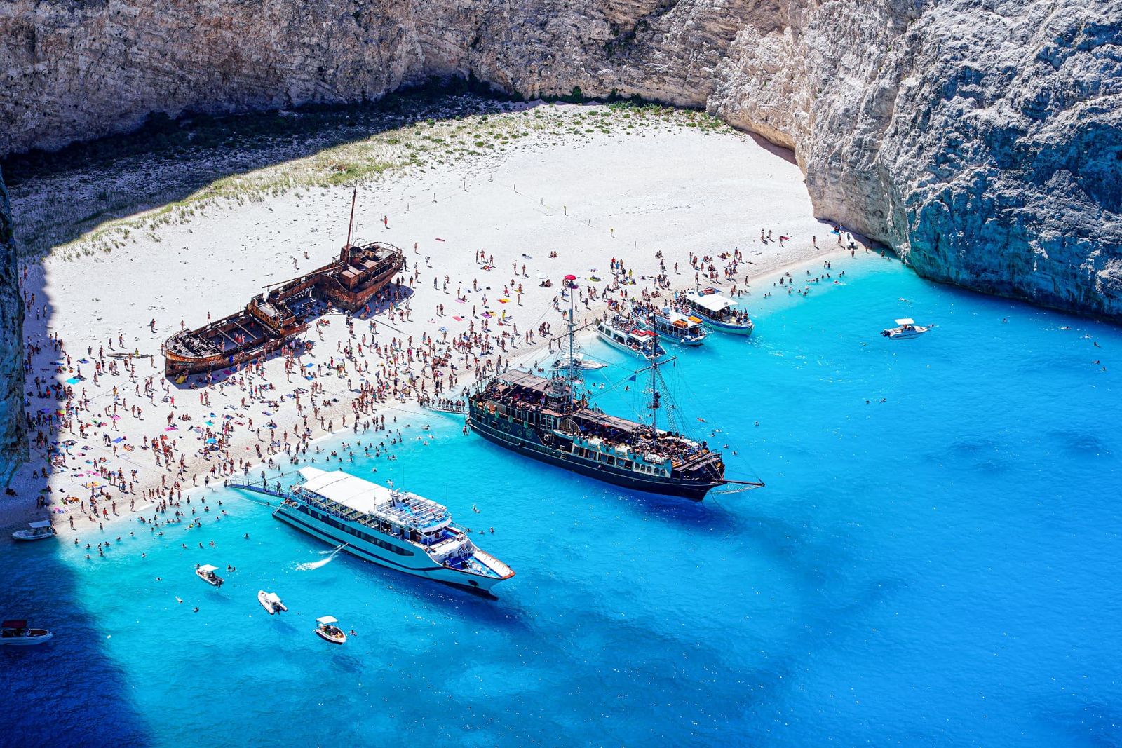 Aerial view of Navagio Beach in Greece with tour boats on turquoise water