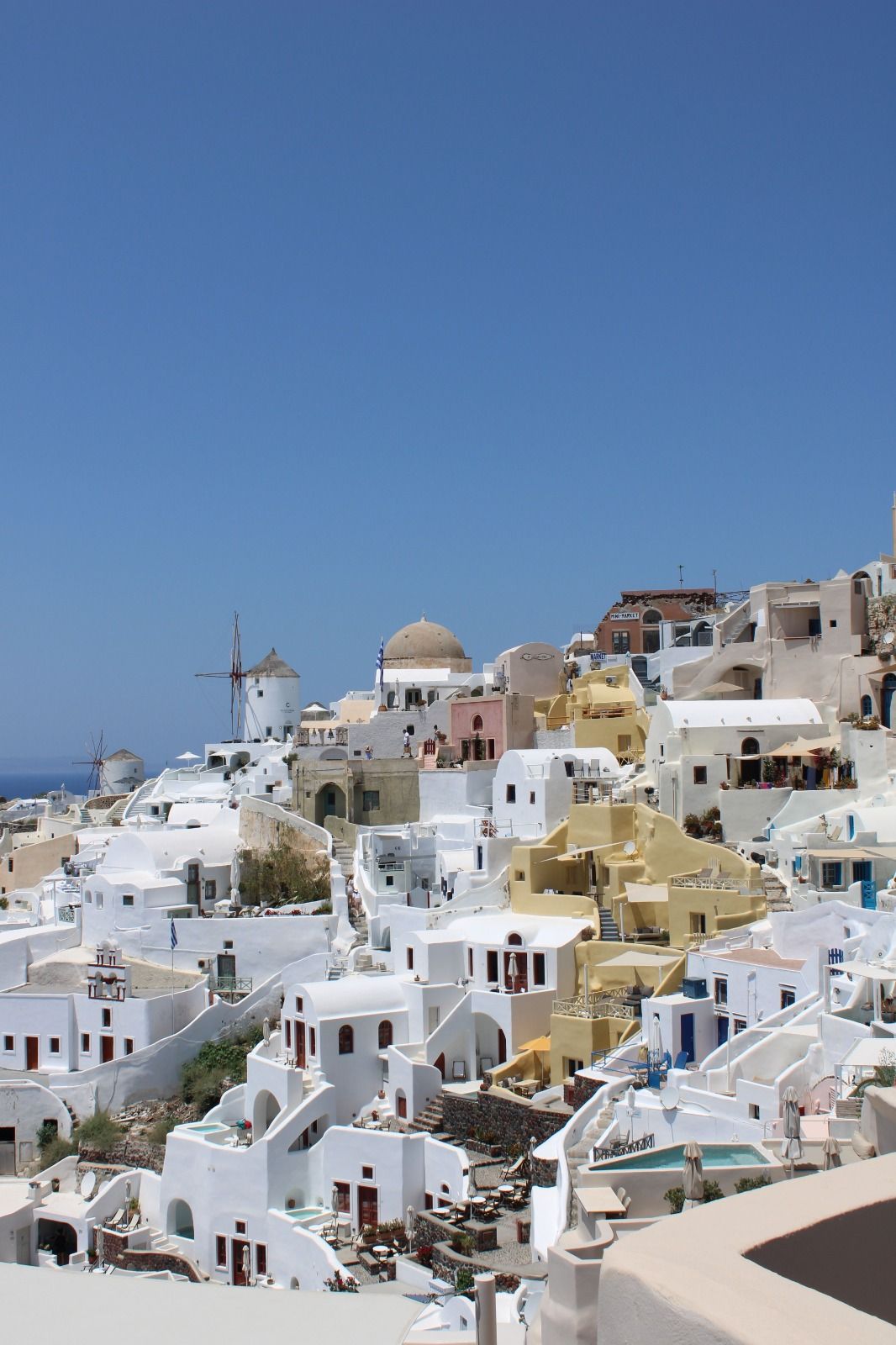 White cliffside houses with yellow accents in Santorini
