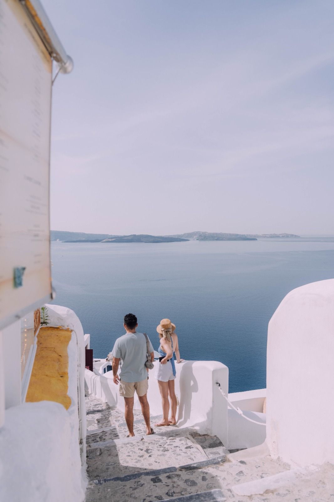 Couple on a Santorini stairway looking out to sea
